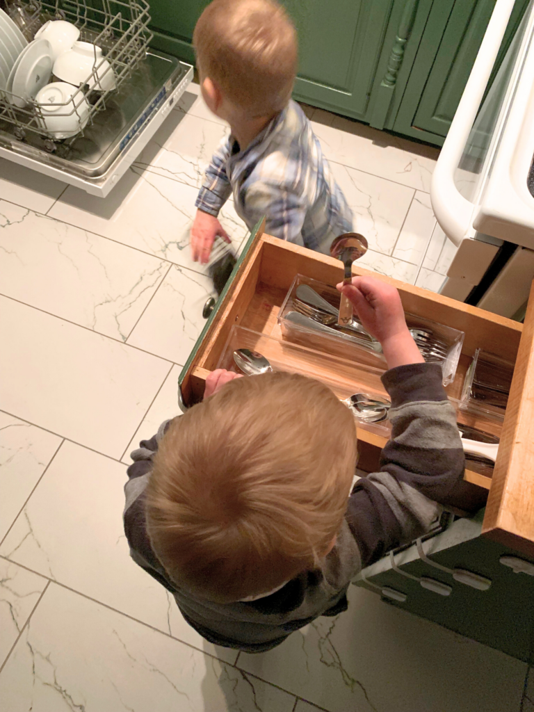 Twins in a Montessori Home emptying dishwasher 