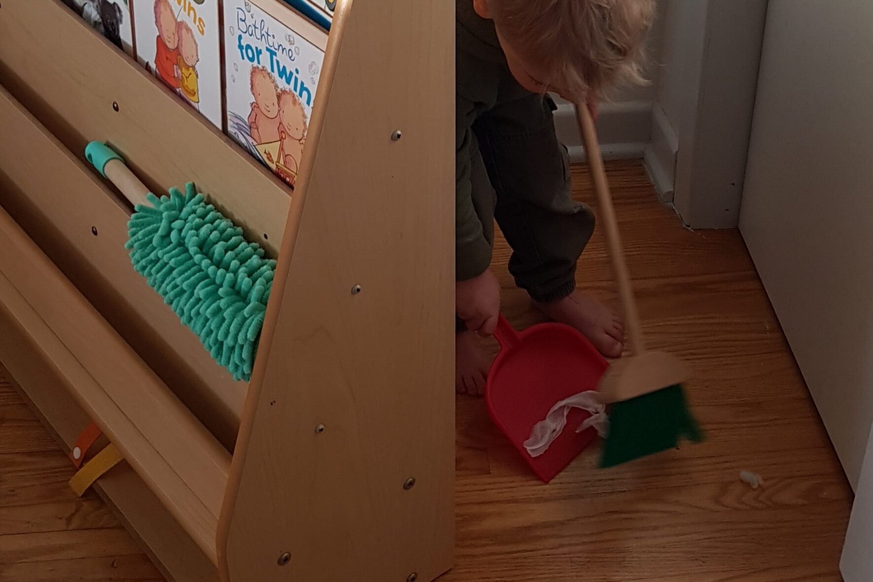 toddler practicing independence sweeping floor Montessori