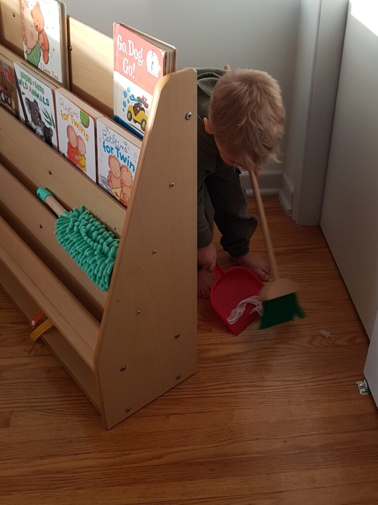 toddler practicing independence sweeping floor Montessori Twins
