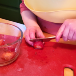 Left handed Montessori child cutting fruit