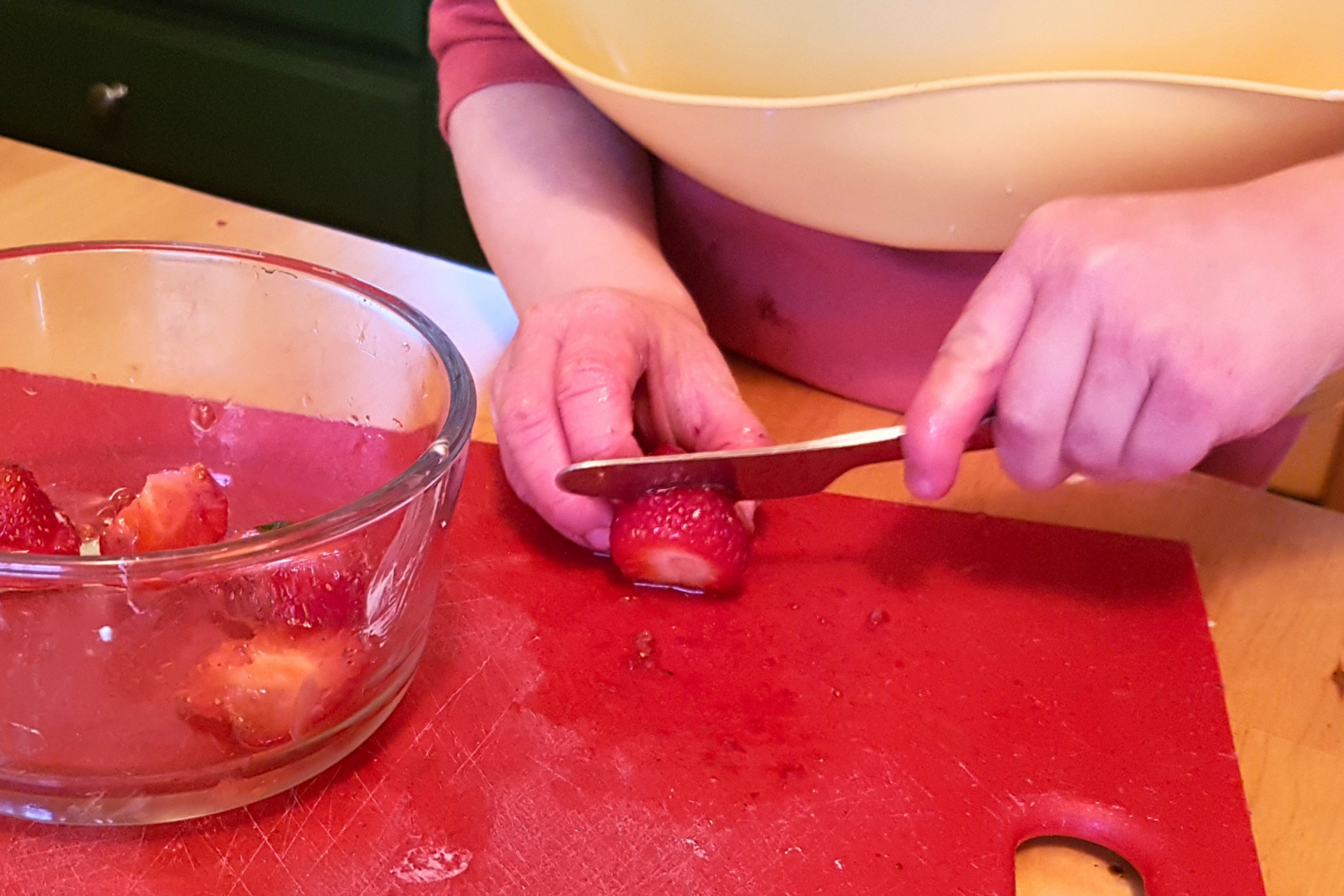 Left handed Montessori child cutting fruit